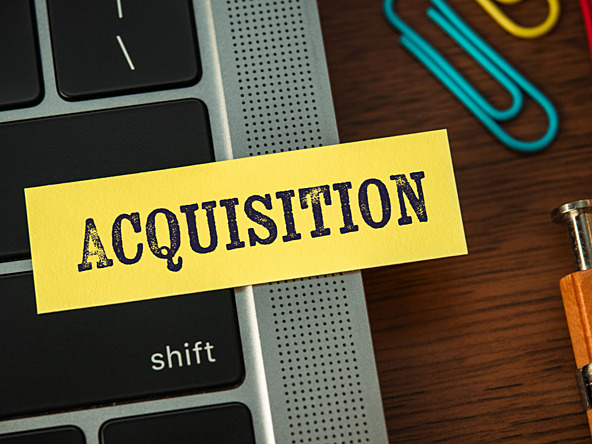 'Acquisition' written on sticky note on laptop